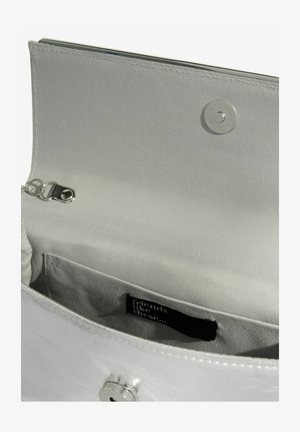 Ezüst fémes kézitáska belseje, sima anyaggal bélelve. Kis zsebbel és kapcsos záródással rendelkezik. Címke belül látható.