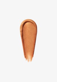 Tache d'enlumineur liquide bronze scintillant avec une texture lisse et courbée sur fond blanc.