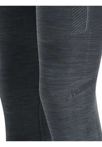 Czarne legginsy sportowe o melanżowej fakturze i dopasowanym kroju. Posiadają subtelne logo na dolnej części nogawki oraz prążkowany panel na udzie.