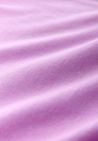 Hellvioletter Baumwollstoff mit glatter Textur, zeigt sanfte Falten und einen dezenten Glanz, geeignet für Kleidung oder Polsterungen.