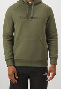 Olijfgroene hoodie van zacht materiaal, met een kangoeroezak, ribgebreide manchetten en een geborduurd logo op de borst.
