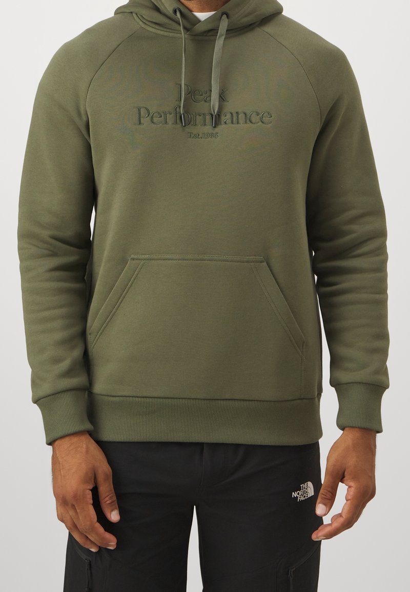 Olijfgroene hoodie van zacht materiaal, met een kangoeroezak, ribgebreide manchetten en een geborduurd logo op de borst.