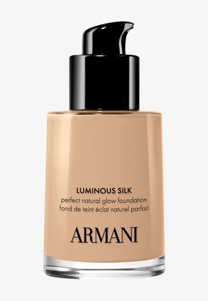 Flacon de fond de teint Armani Luminous Silk avec distributeur noir et liquide beige visible à l'intérieur.