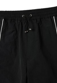 Zwarte shorts met een elastische tailleband, voorzien van een trekkoord en metalen uiteinden, en witte zijlijnen. Gemaakt van lichtgewicht stof.