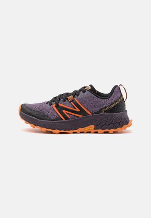 Purple and black athletic shoe with orange accents, featuring a textured mesh upper and a Vibram sole for traction.