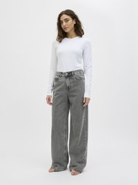 Long-sleeve white shirt paired with high-waisted, wide-leg gray jeans featuring a textured fabric and casual fit, with an unembellished design.