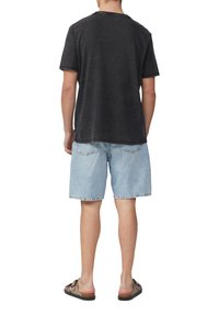 Donkergrijze, getextureerde T-shirt met korte mouwen gecombineerd met lichtblauwe spijkerbroekshorts; casual schoenen maken de outfit compleet. Geen zichtbare patronen of accenten.