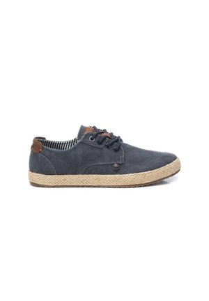 Zapato casual azul marino de lona con cordones, suela trenzada de yute y lengüeta trasera de cuero marrón, mostrado de perfil sobre un fondo blanco.