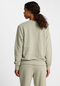 Lichtgroene sweatshirt met een ronde hals, geribbelde manchetten en een geribbelde zoom. Zacht, textuurstof, gestyled met bijpassende broek.