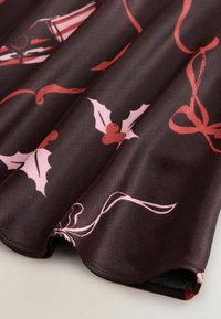 Tessuto in raso scuro con finitura lucida, caratterizzato da fiocchi rosa e motivi di agrifoglio. Dettaglio con bordo curvo lungo l'orlo.