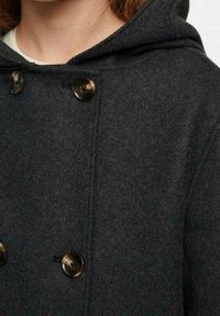 Kolgrå ullkappa med huva, med två stora runda knappar och en mjuk yta. Enkelt mönster utan ytterligare dekorationer.