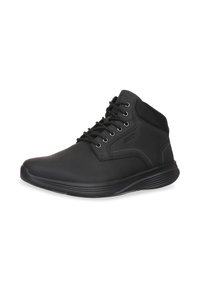 Zapatillas altas negras hechas de material sintético. Incluyen un diseño con cordones, un collar acolchado y una superficie lisa y suave.