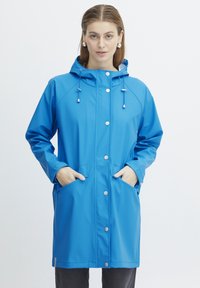 Blauwe waterdichte regenjas met een capuchon, drukknoopsluiting en zakken. Heeft een gladde textuur en een relaxte pasvorm, ideaal voor slecht weer.