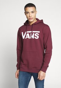 Sčervenej mikina s kapucňou a bielym logom "VANS", má klokanku, nastaviteľnú šnúrku na kapucni a pletené manžety. Mäkká tkanina.