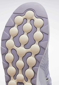 Semelle de chaussure présentant un motif arrondi et texturé en violet clair et crème. Matériau en caoutchouc avec des éléments en relief pour la traction.