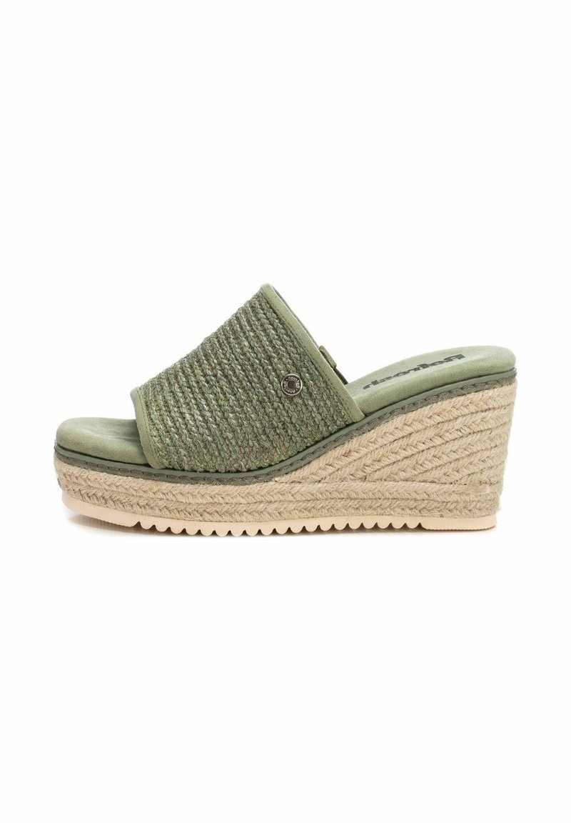 Sandaia verde con parte superior de tejido trenzado, detalles de cuerda al estilo esparto y suela texturizada. Parte frontal baja y parte trasera más alta para mayor soporte.