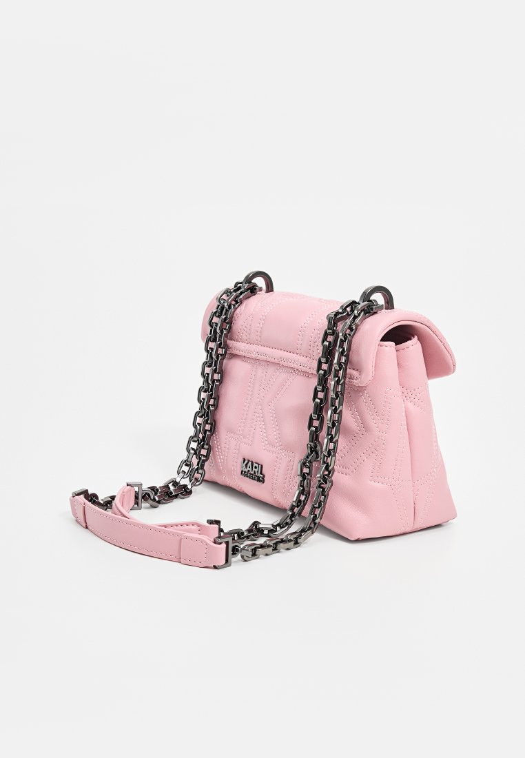 Sac à main en cuir matelassé rose avec un haut arrondi, une chaîne et un logo. Il possède une fermeture à rabat et une texture lisse avec une forme structurée.