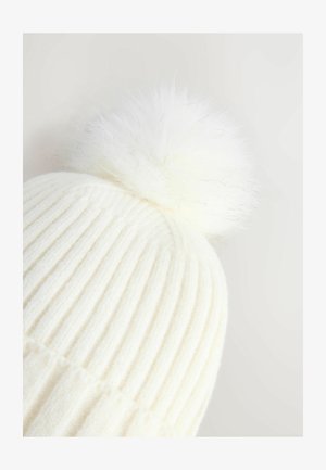 Ribidega valge kudumüts, millel on pehme valge pom-pom peal, pakkudes pehmet tekstuuri, et tagada lisasoojus ja mugavus.