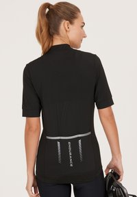 Svart kortärmad cykeltröja med hög krage, med reflexdetaljer och en logotyp på ryggen. Slät, stretchig tyg.