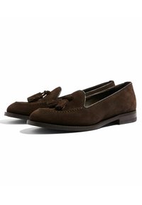 Mocassini in suede marrone con un accento a nappina, caratterizzati da un design cucito, tacco basso impilato e una fodera liscia.