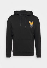 Felpa nera con cappuccio realizzata in cotone. Presenta una tasca frontale a marsupio e un motivo a chevron in giallo, grigio e grigio scuro sul petto.