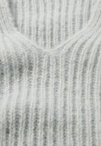 Hellgrauer, gestrickter Stoff mit V-Ausschnitt und vertikalen Rippen sowie einer weichen, leicht flauschigen Textur.