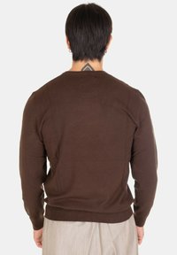 Maglione marrone lavorato a maglia con scollatura rotonda e maniche lunghe. Presenta polsini e orlo ribattuti. Texture liscia, design aderente.