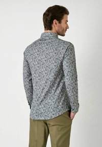 Langarmhemd mit floralen Mustern in Blau-, Weiß- und Grüntönen. Hergestellt aus weichem Stoff, mit klassischem Kragen und geknöpften Manschetten.