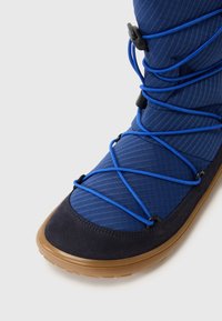 Stivale in tessuto blu con design testurizzato, dettagli in suede e lacci elasticizzati. Presenta una punta arrotondata e una suola in gomma per una migliore aderenza.