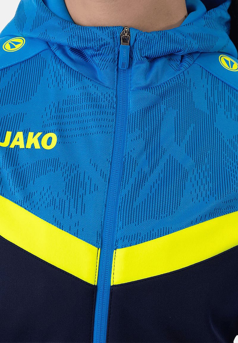 Blauwe ritshoodie met capuchon, van een textuurstof, met gele accenten en het logo "JAKO" prominent op de borst weergegeven.