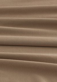 Tissu marron à la texture lisse, avec des plis verticaux, un poids moyen et un motif de tissage uniforme.