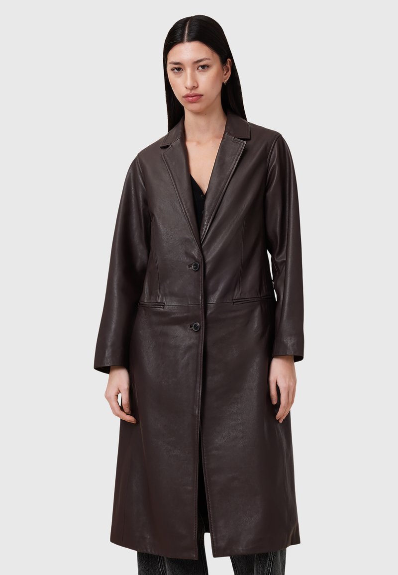 Cappotto in pelle marrone con un taglio lungo e dritto, rever a punta, due tasche anteriori e tre bottoni, caratterizzato da una texture liscia e un design minimalista.