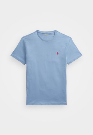 Lichtblauw T-shirt met korte mouwen en ronde hals, met een klein rood geborduurd logo van een paard en ruiter op de linkerborst.