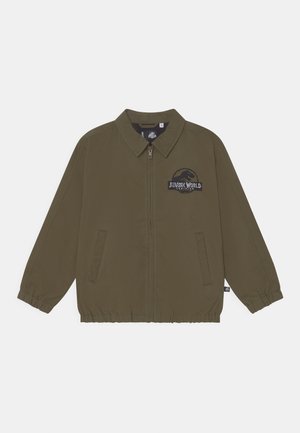 Casaco leve verde-oliva com fecho de correr, dois bolsos laterais, punhos elásticos e um logótipo do Jurassic World bordado no peito.