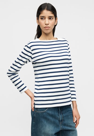 Μπλούζα μακρυμάνικη με στρογγυλή λαιμόκοψη, διακοσμημένη με οριζόντιες λευκές και ναυτικές ρίγες σε απαλό ύφασμα. Κομμένη με ίσια γραμμή, συνδυασμένη με τζιν.
