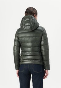 Doudoune vert foncé avec capuche, affichant un design matelassé et une texture lisse. Le dos présente des coutures verticales et une coupe ajustée.