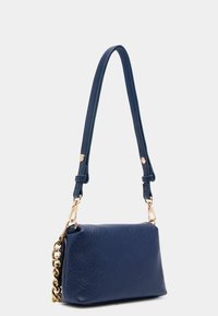 Borsa a spalla in pelle blu navy con una trama liscia, una lunga tracolla regolabile e dettagli in metallo dorato con catena.