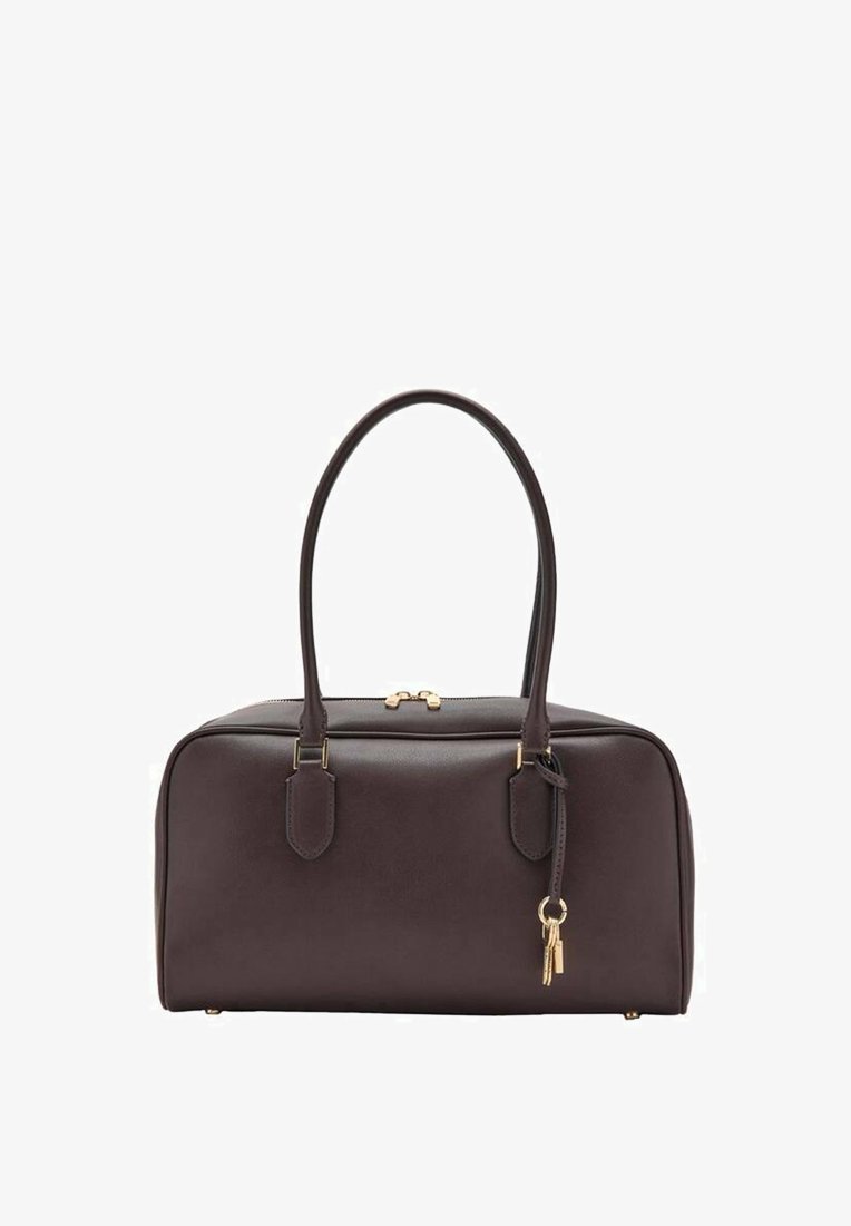 Sac à main en cuir marron foncé à forme arrondie, avec doubles poignées, ferrures dorées et un petit porte-clés suspendu. Texture lisse, design minimaliste.