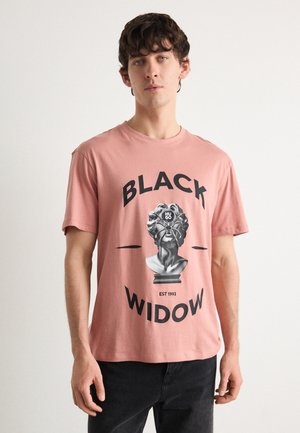Lyserød bomulds t-shirt med et grafisk billede af en buste og teksten "BLACK WIDOW" i fede sorte bogstaver samt et etableringsår fra 1993.