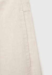 Light beige linen fabric with a soft texture, featuring a clean seam detail on one side. The material appears breathable and lightweight.