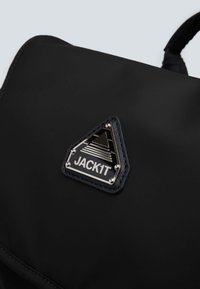 Zaino nero realizzato in materiale resistente, con una toppa a forma triangolare con accenti in argento. Texture liscia con cuciture rinforzate.