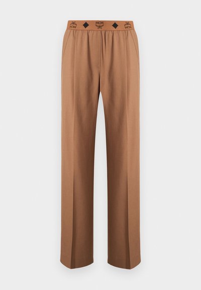 Pantalon marron droit avec taille élastique arborant un logo MCM noir et des détails en motif losange.