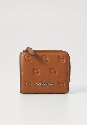 Tan leather wallet with embossed logo pattern, featuring a zip closure and silver brand name accent on the front. Compact rectangular shape.