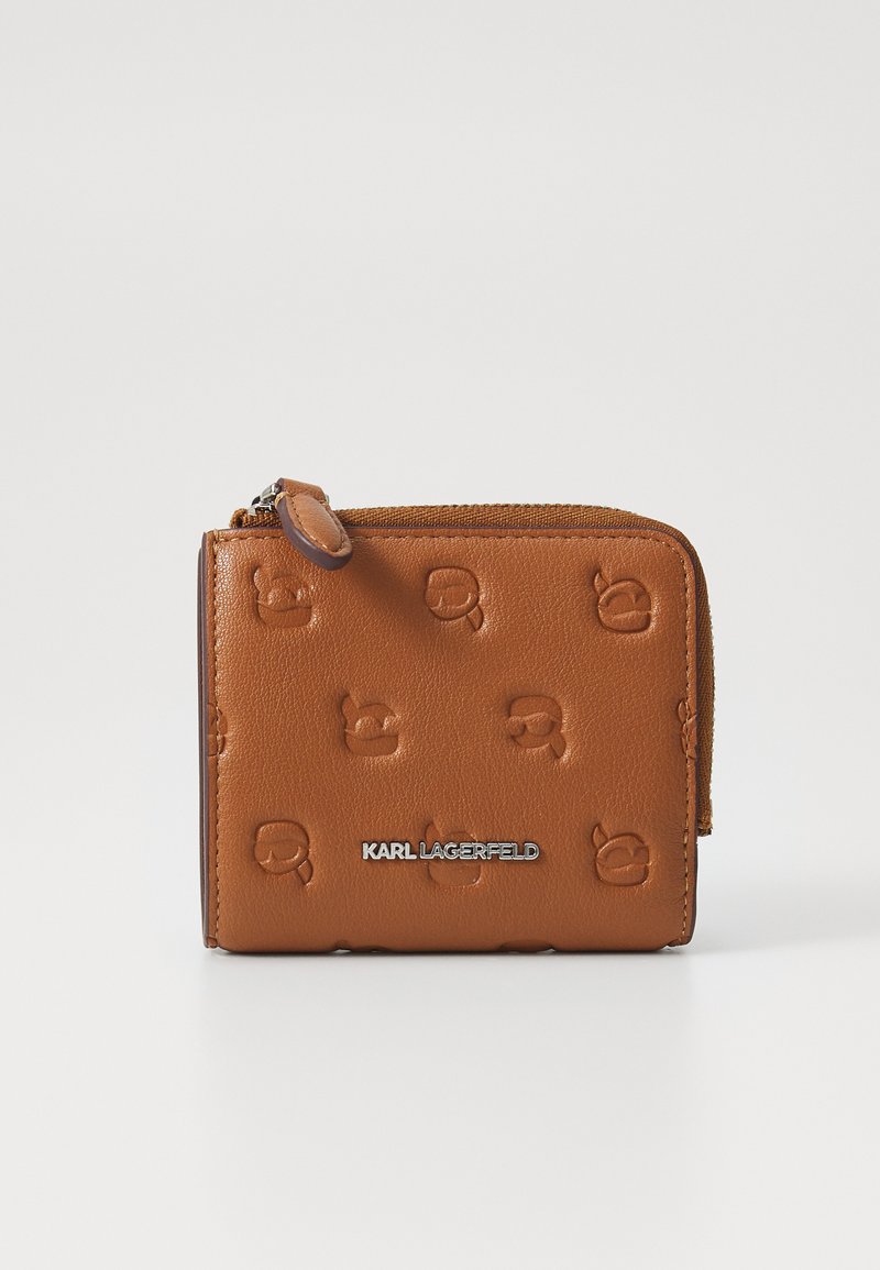 Tan leather wallet with embossed logo pattern, featuring a zip closure and silver brand name accent on the front. Compact rectangular shape.