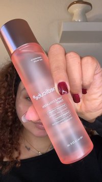 Transparent rosa flaska med en bronsfärgad kork märkt "Triple Collagen Toner." Innehåller produktspecifikationer och användningsinstruktioner tryckta i vitt.