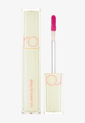 Klar rektangulær tube med gult skær, pink tekst og en pink applikatorstang. Formlen ser flydende og dewy ud.