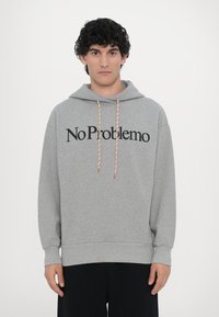 Grau Hoodie aus weichem Material mit dem vorderen Aufdruck "No Problemo", ausgestattet mit roten und weißen Kordeln und einem lockeren Schnitt.