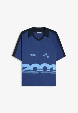 Polo bleu à manches courtes avec col et manches noires, texte "SHORE SUPPLY", trois étoiles et grand motif "2001" sur le devant.