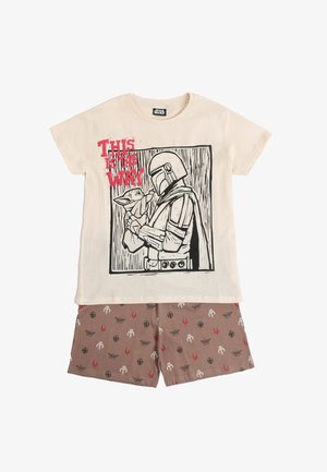 Conjunto de pijama infantil de Star Wars con texto "This is the Way", que presenta a Mandaloriano sosteniendo a Grogu en la parte superior color crema y pantalones cortos marrones con estampado.
