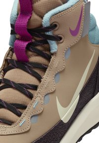 Pūkas vidēji augsta sneaker ar lavandas un melnām auklām, zilajiem akcentiem, teksturētu zoli un izteiktu balto swoosh detaļu.